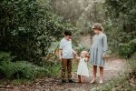 Siblings hold their baby sisters hands during a photo session